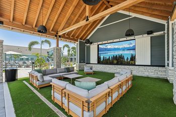 A wooden patio with a couch and a television screen. at The Junction at Rockledge Apartments, Florida